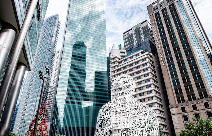 Statua di umo fatta di lettere e numeri bianchi guarda grattacieli singapore